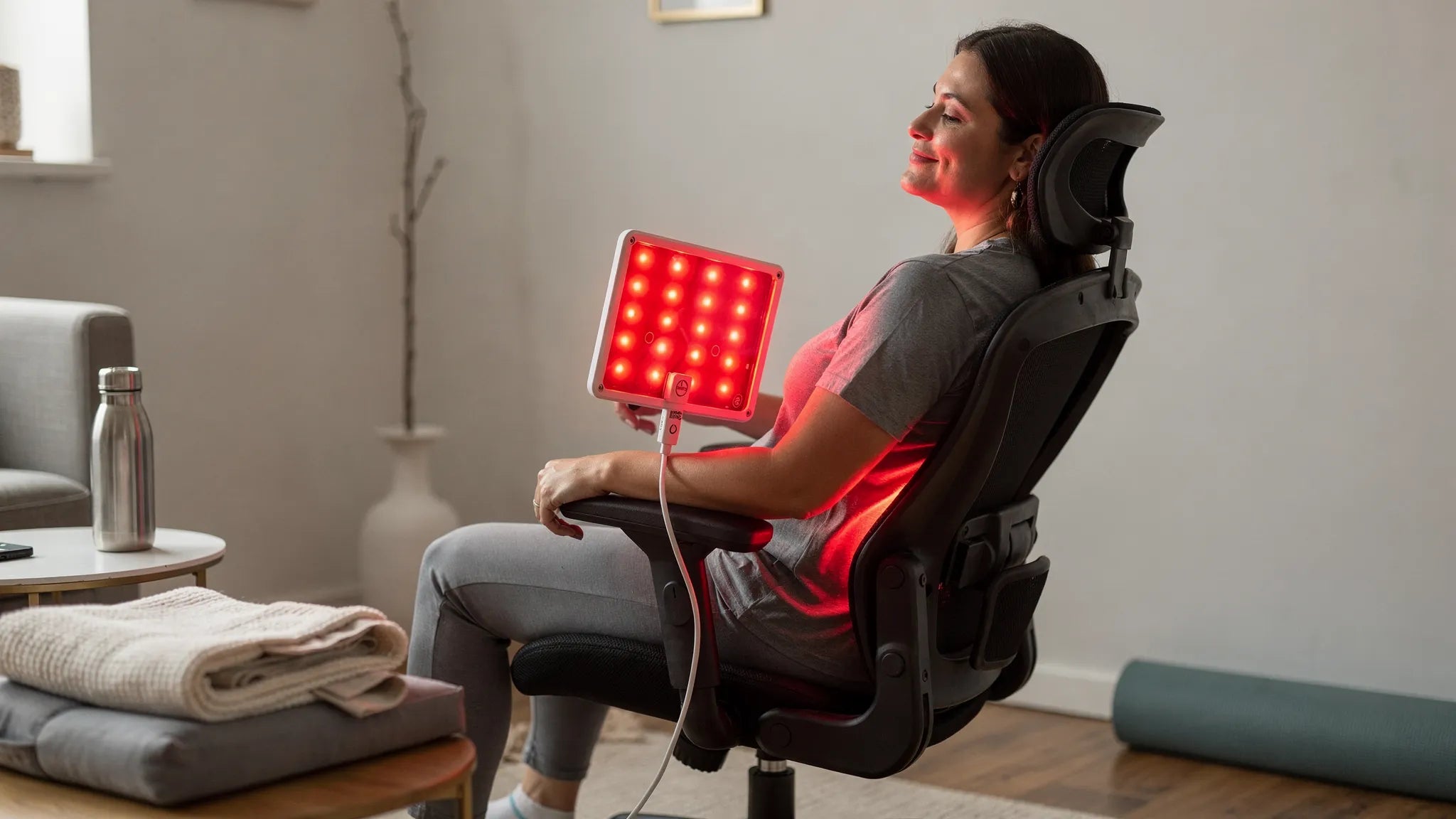HealthLight General Pain Relief Kit in use — person applying red and near-infrared LED contact pad therapy for chronic pain relief and muscle recovery at home